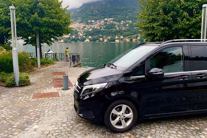 Executive van near picturesque lakeside on Milan to Courchevel private transfer journey.