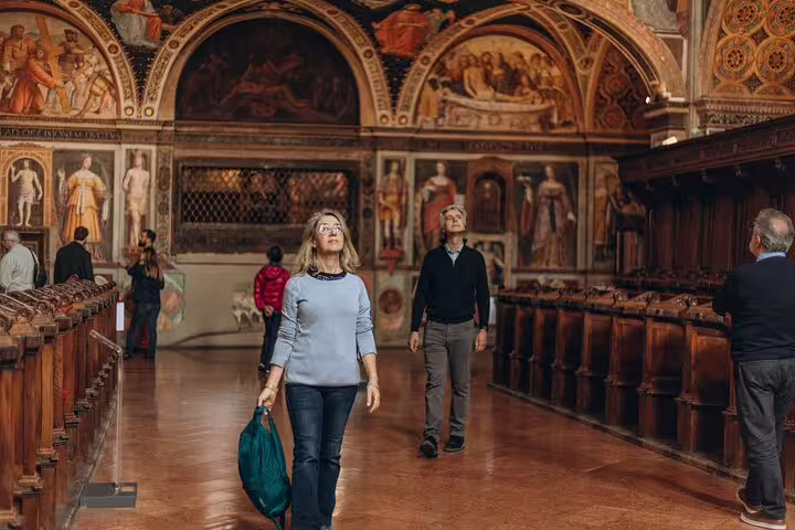 Visitors explore the ornate interiors of a historic Milanese building, a highlight of the Milano walking tour featuring Duomo and Castle.