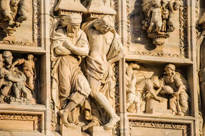 Intricate stone carvings on Milan's Duomo facade, showcasing Renaissance artistry on a private walking tour of Duomo and Castle.