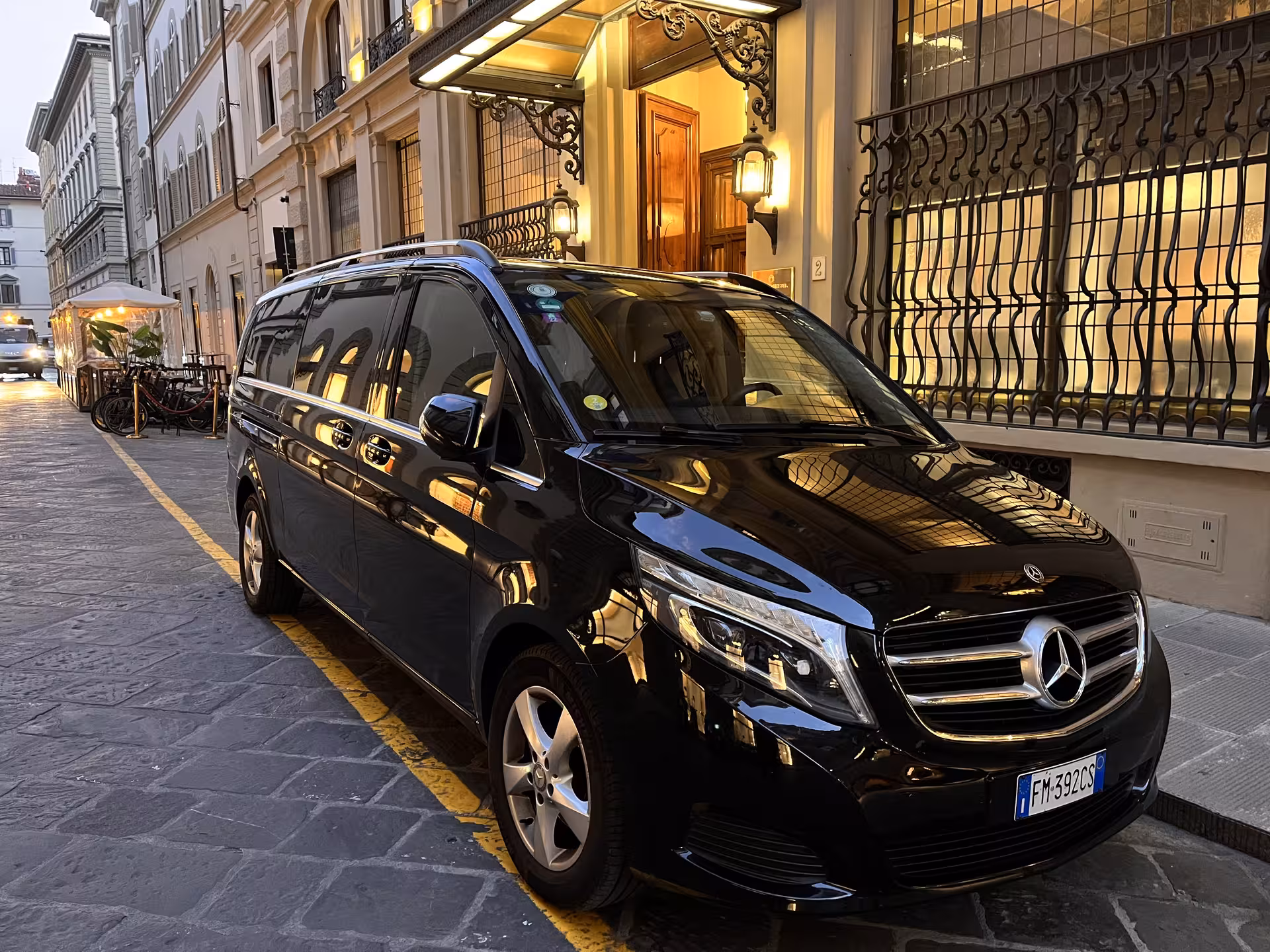 Luxurious black Mercedes van parked on a charming street in Florence, perfect for Milan to Florence transfers.
