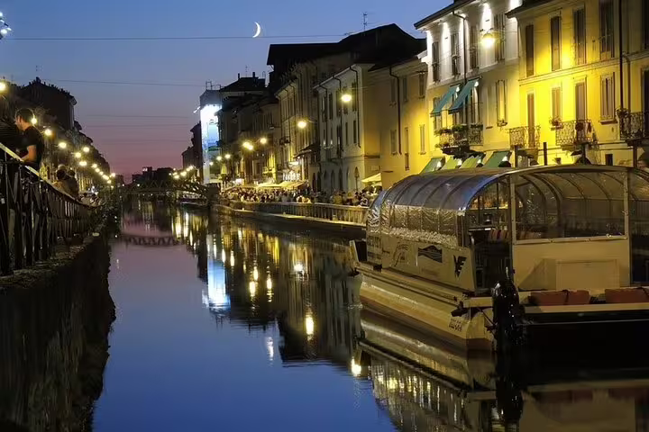 Evening canal scene in Milan's Navigli district, with vibrant reflections and lively ambiance on a private night tour.
