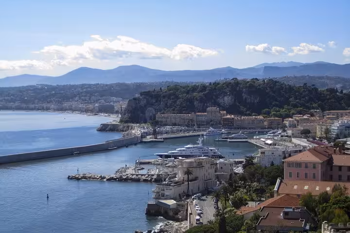 Scenic view of Nice harbor with yachts and coastal landscape on private transfer from Milan to Nice.