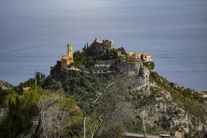 Hilltop village with church overlooking the sea on the route from Milan to Nice for private transfer.