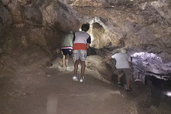 Visitors explore the rugged interior of Milatos Cave, showcasing its natural rock formations on a guided tour.