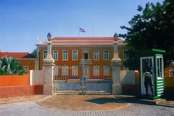 Colonial-style government building in Mindelo, São Vicente, featuring striking architecture and a guarded entrance.