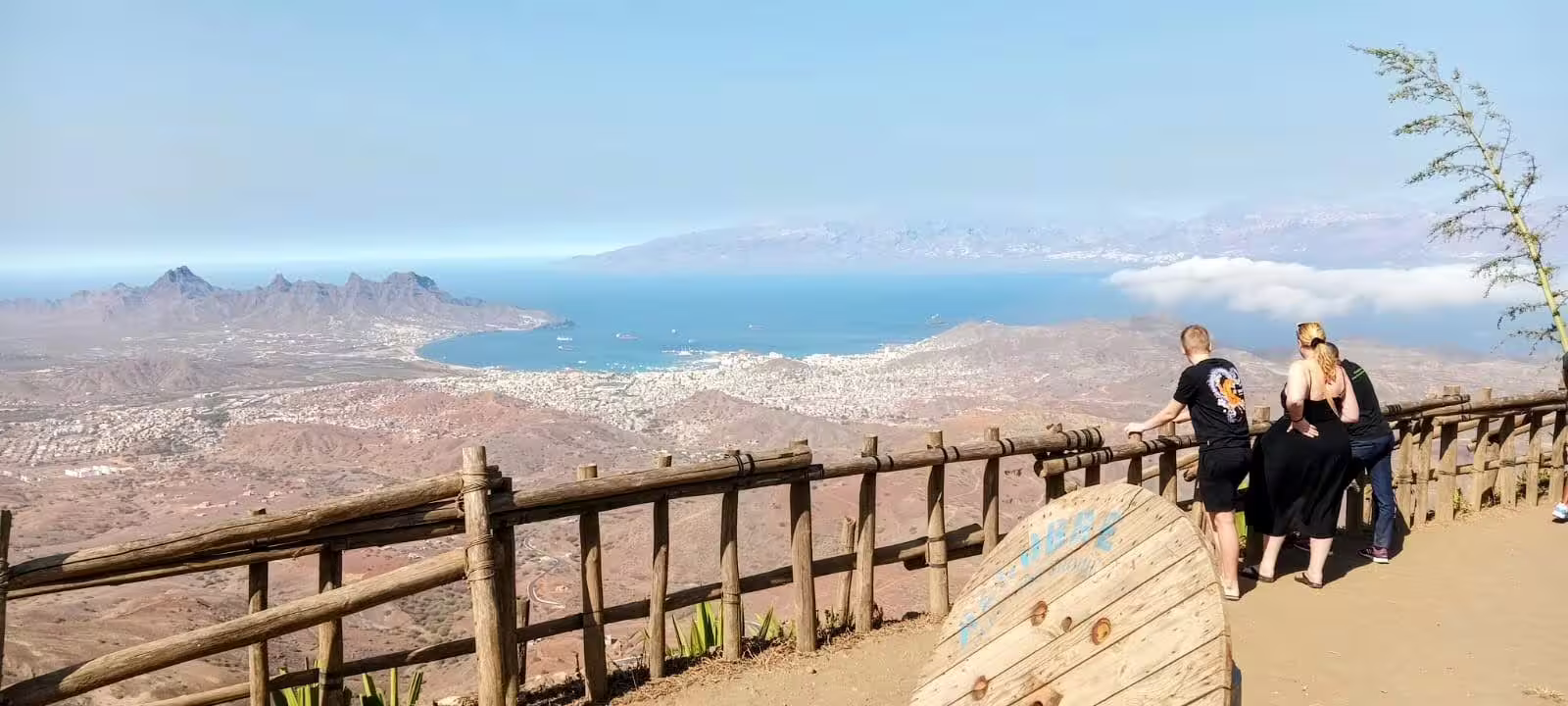 Tourists enjoying panoramic views of Mindelo and São Vicente's coastline from a scenic lookout on a full day island tour.