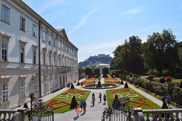 Mirabell Palace Gardens in Salzburg with flowerbeds and fortress views on a private Vienna day trip