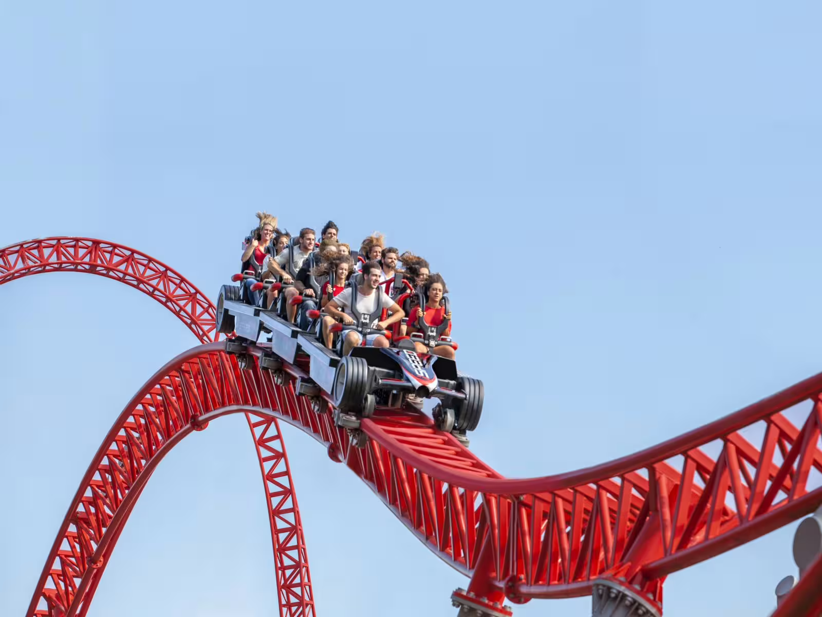 Mirabilandia Amusement Park open date entry, high-speed red roller coaster with riders on twisting track