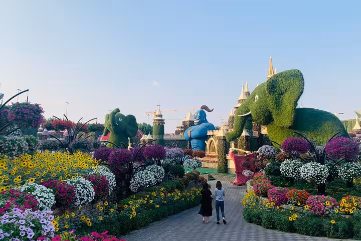 Ras Al Khaimah Adventure Await pass view of flower garden walkway with giant topiary elephants and castle