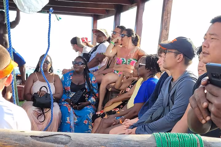 Visitors relaxing on a boat during the Mnemba Island Dolphin & Snorkeling Tour, capturing the essence of a Zanzibar adventure.
