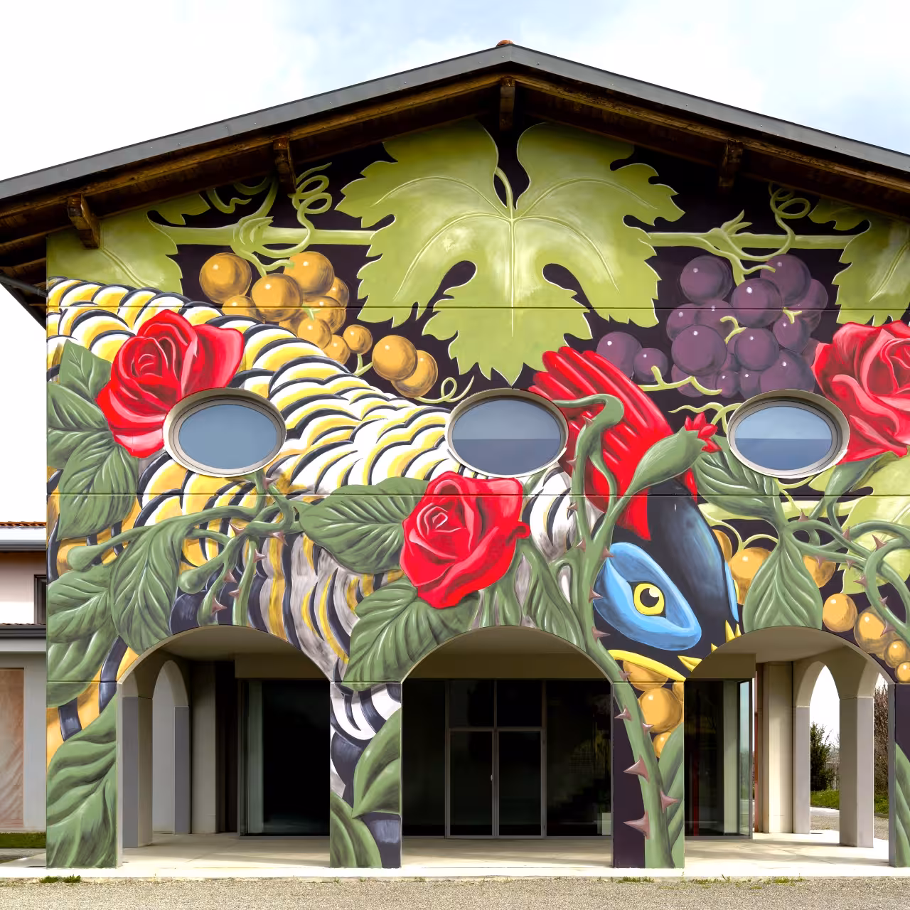 Colorful vineyard mural on Modena acetaia building, a stop on balsamic vinegar and Parmigiano tour