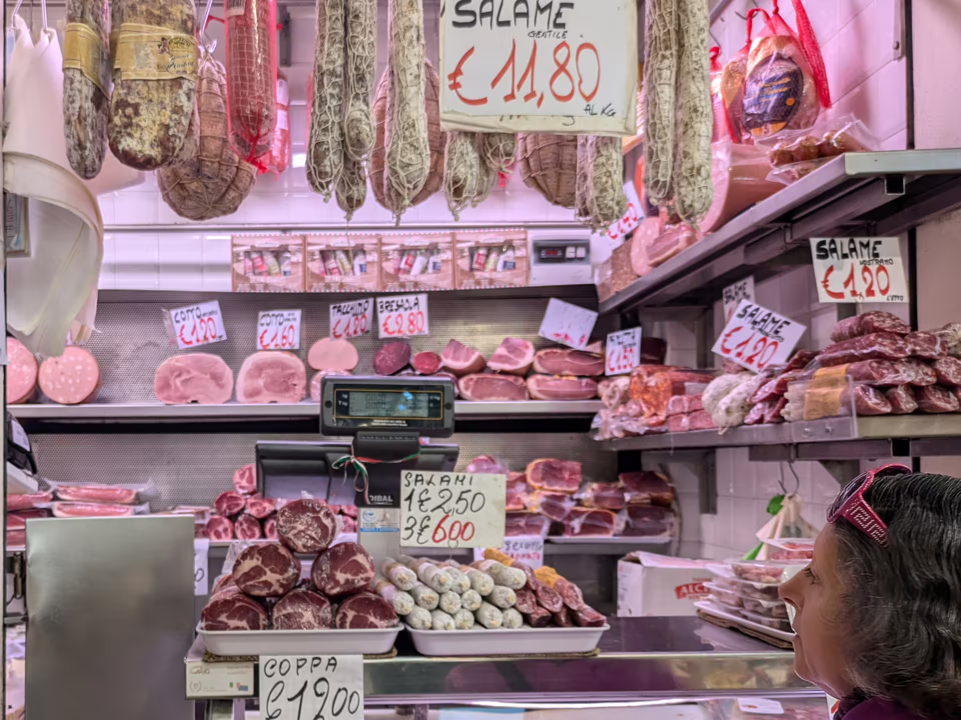 Local Modena butcher displaying an array of artisanal salami and cured meats, perfect for food tour sampling.