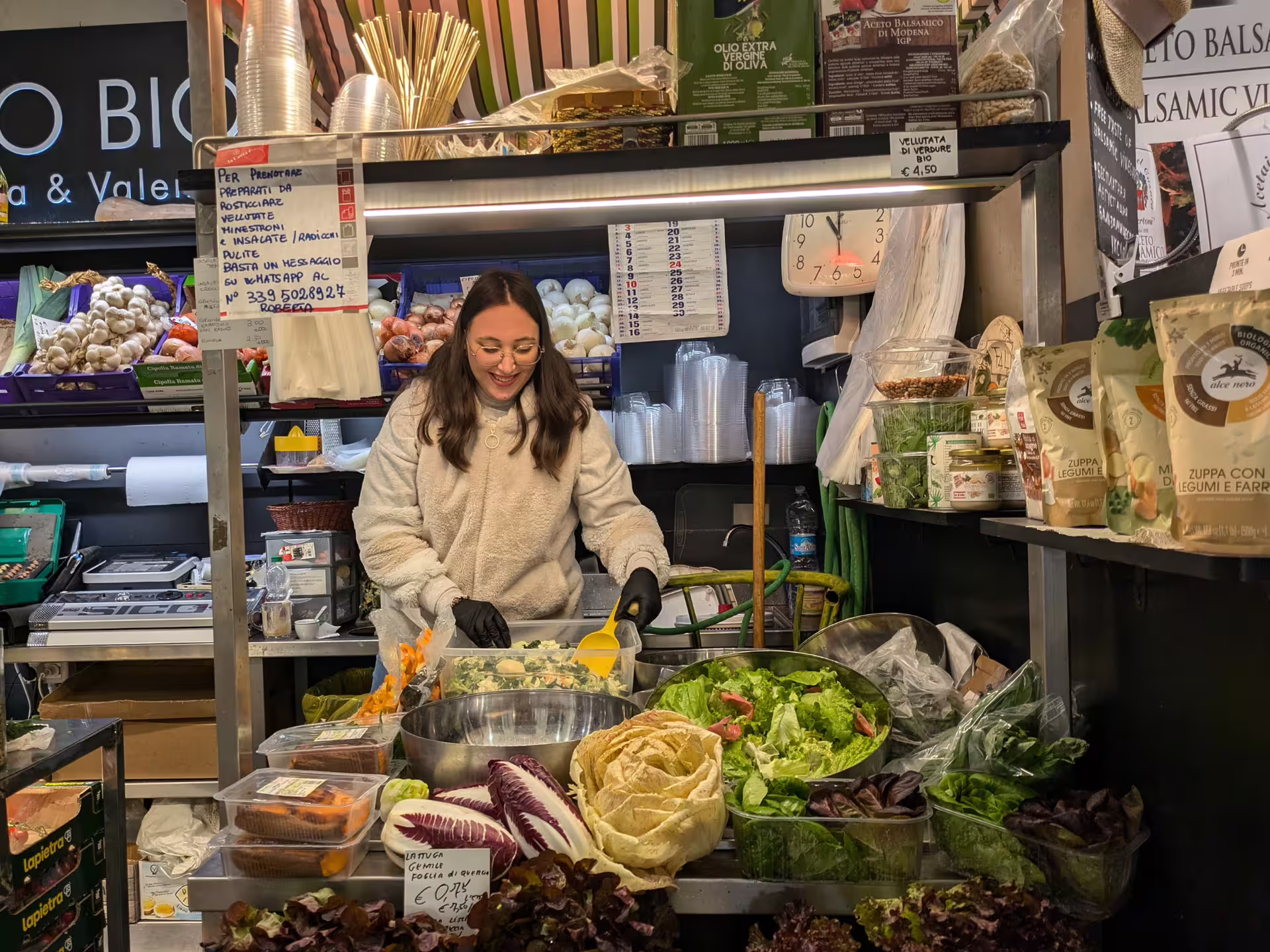 Local vendor preparing fresh salads at Modena market, a highlight of the Modena Food Tour: Sightseeing & Taste.
