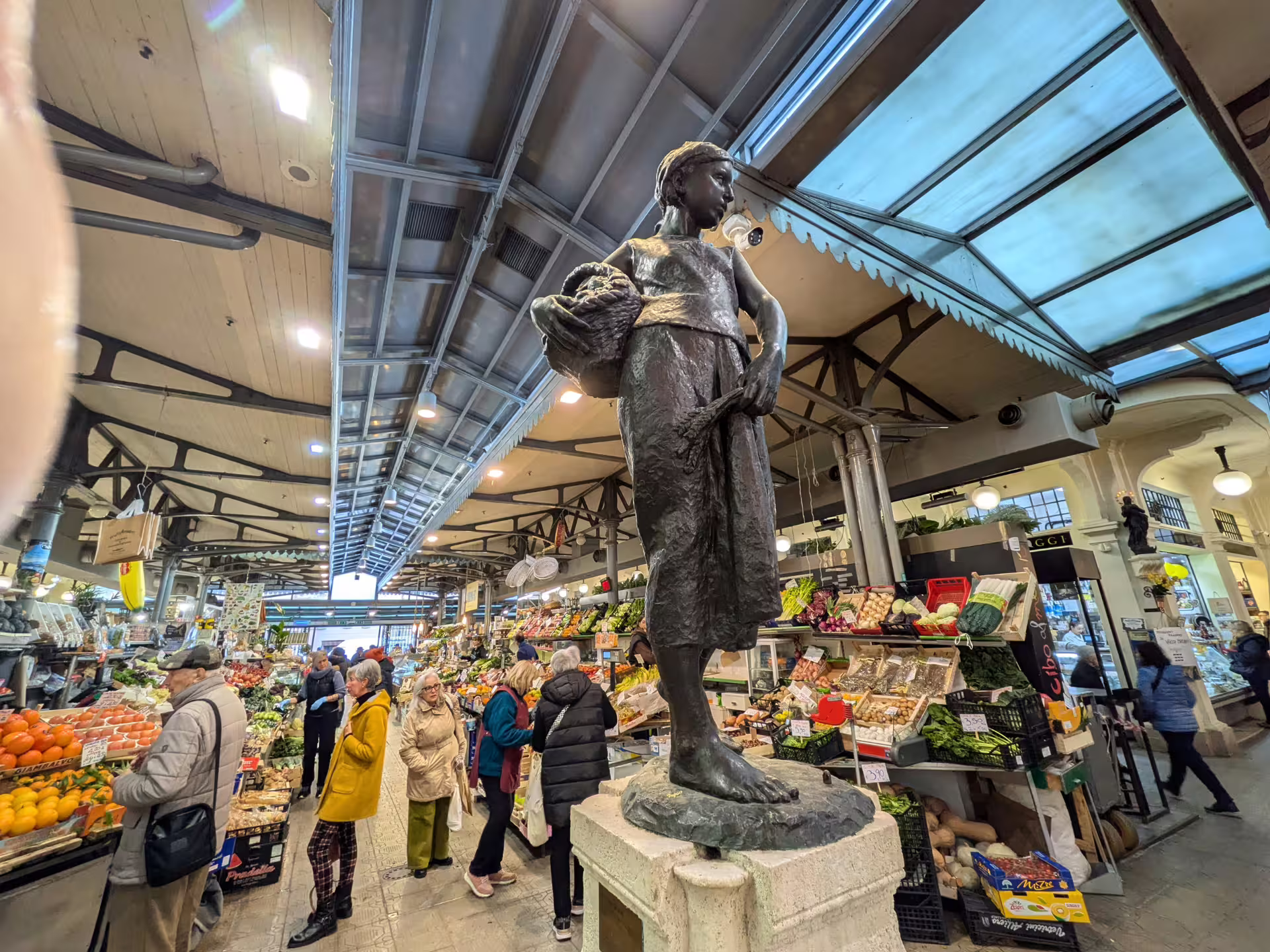Bustling Modena market with iconic statue, showcasing vibrant local produce on the Modena Food Tour: Sightseeing & Taste.