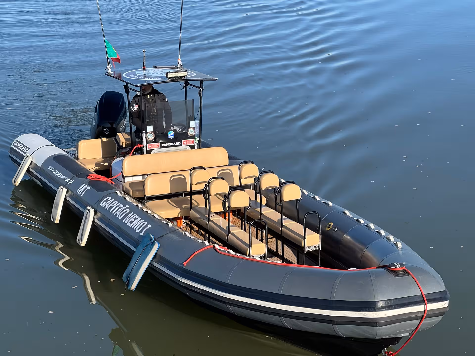 Modern RIB speedboat with cushioned seats and skipper ready for a private tailor‑made boat charter on calm coastal waters