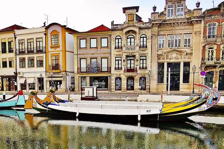 Traditional moliceiro boat docked along the canal with vibrant architecture in Aveiro on a private Costa Nova tour from Porto.