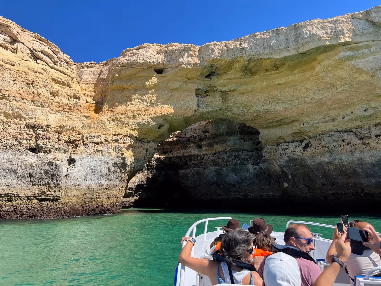 Visitors on a boat exploring stunning sea cave formations during Moments Caves & Coastline tour.