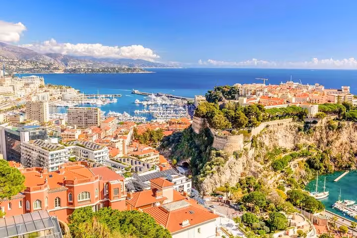 Panoramic view of Monaco's harbor with vibrant buildings and yachts along the French Riviera coastline.