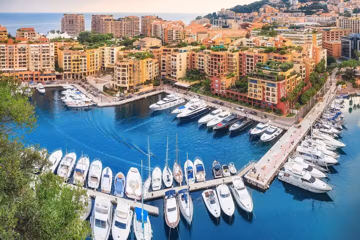 Aerial view of Monaco's luxurious marina with yachts and colorful buildings, perfect for a Riviera private tour.