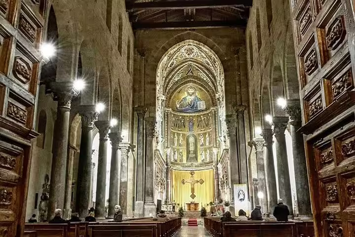 Interior of Monreale Cathedral with golden Byzantine mosaics and arches on a guided private tour from Palermo
