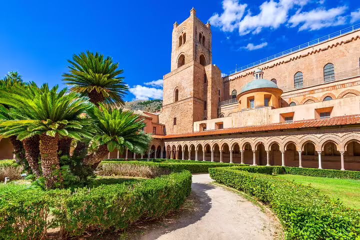 Monreale Cathedral cloister courtyard with palm trees near Palermo, key stop on private Sicilian day trip excursion