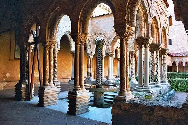 Cloister of Monreale Cathedral near Palermo with ornate Norman-Arab arches, twisted columns and central fountain on private tour