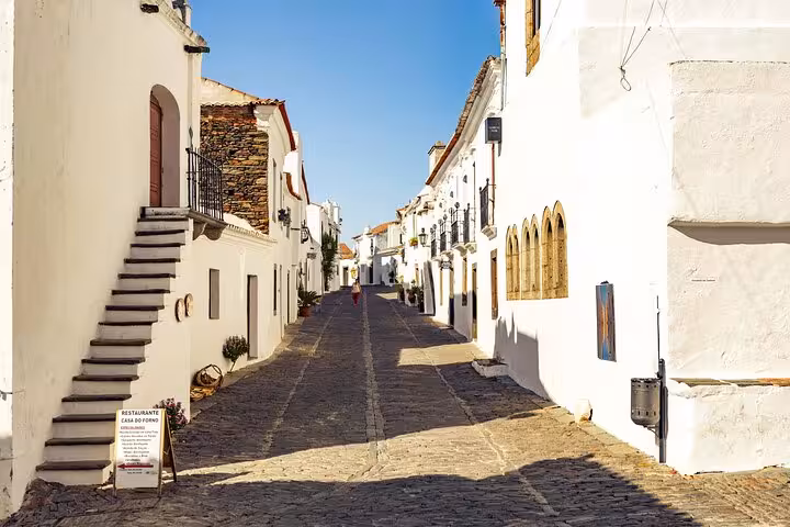 Picturesque Monsaraz street with historic white buildings and a cobblestone road, perfect for a private walking tour.