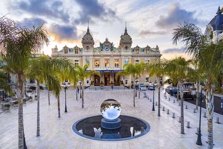 Grand facade of Monte Carlo Casino with palm trees, ideal for Cannes private shore excursion.
