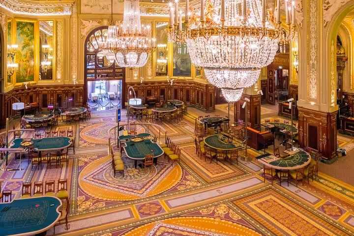 Opulent interior of Monte-Carlo casino with chandeliers and gaming tables, highlighting luxury on a guided tour.