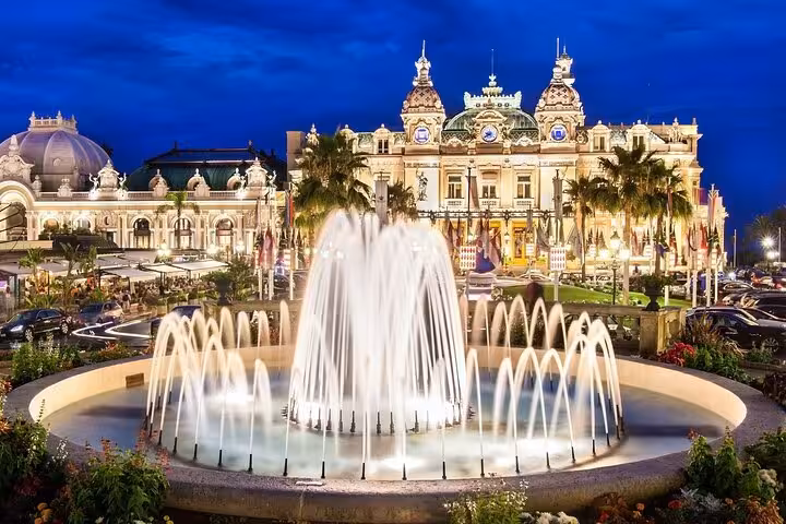 Illuminated Monte Carlo Casino and fountain at night, highlighting the elegance of Monaco's vibrant nightlife.