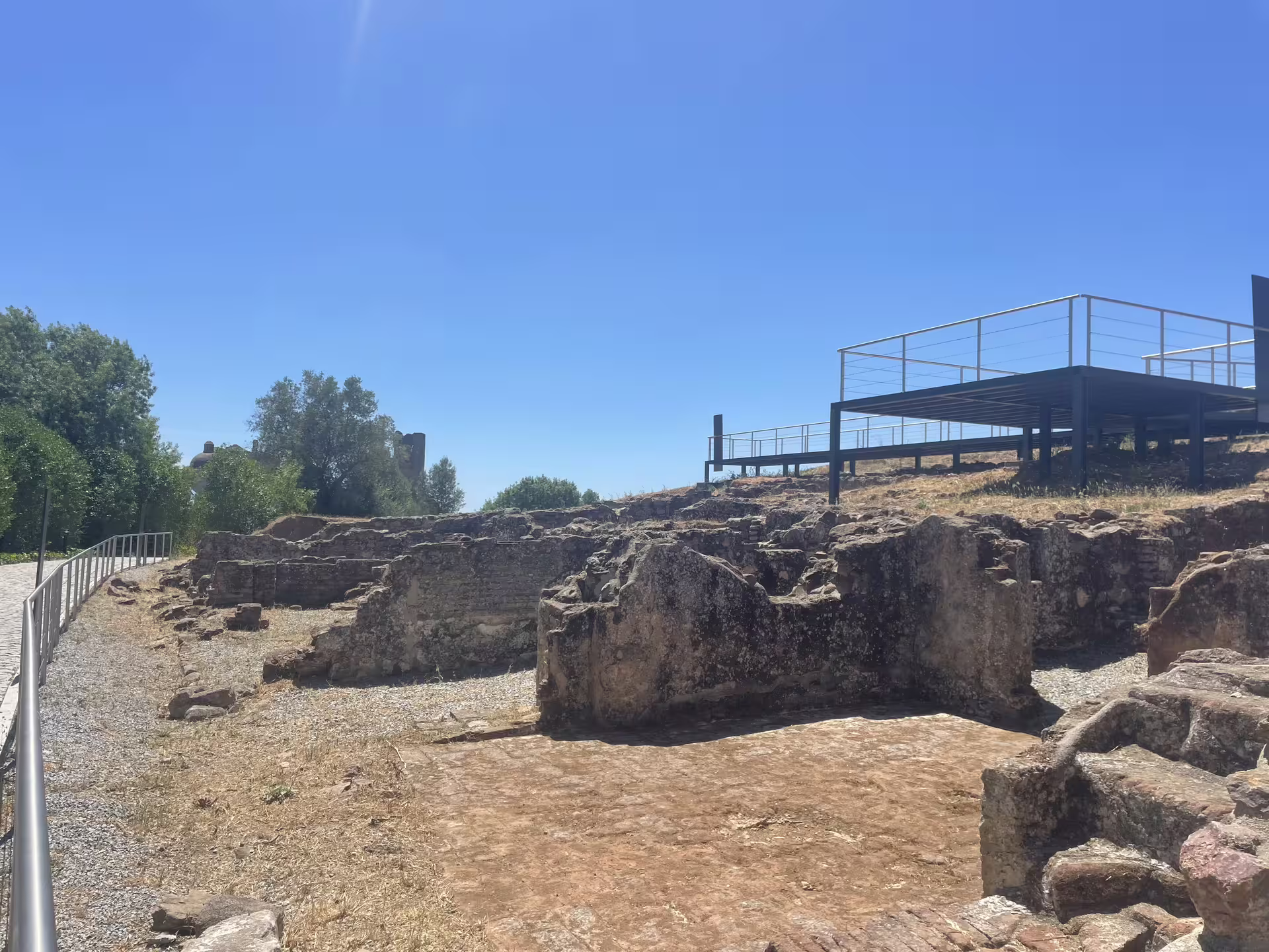 Explore the ancient ruins of Montemor-o-Novo Castle with blue skies and lush greenery.