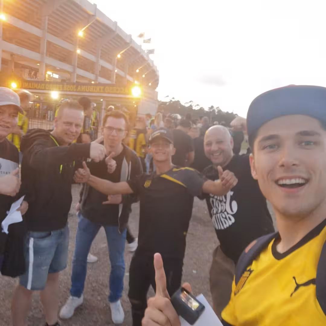 Fans pose outside Montevideo stadium before Peñarol matchday, local-led soccer experience with tickets and vibes
