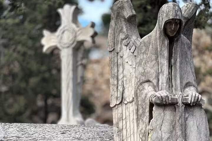 Mystical hooded angel sculpture in Montjuïc Cemetery, offering a glimpse into its hidden art.