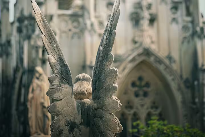 Angel statue with detailed wings, a highlight of the Montjuïc Cemetery walking tour.