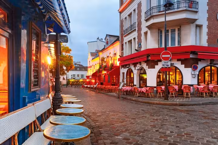 Montmartre Paris café street at dusk, perfect stop on street art walking tour with French drink tasting