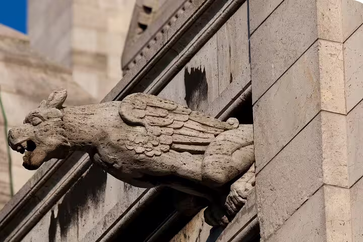 Stone gargoyle on a Paris church facade in Montmartre, a hidden detail to spot on a self-guided scavenger hunt