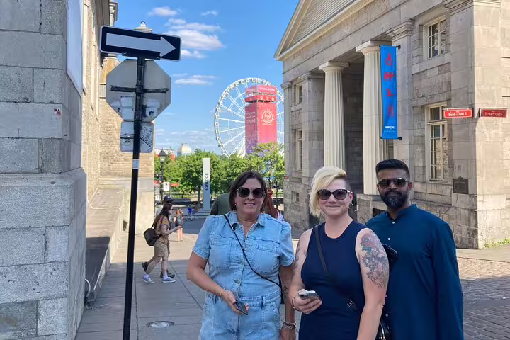 Friends on Montréal scavenger hunt walking tour near Old Port, with La Grande Roue Ferris wheel behind