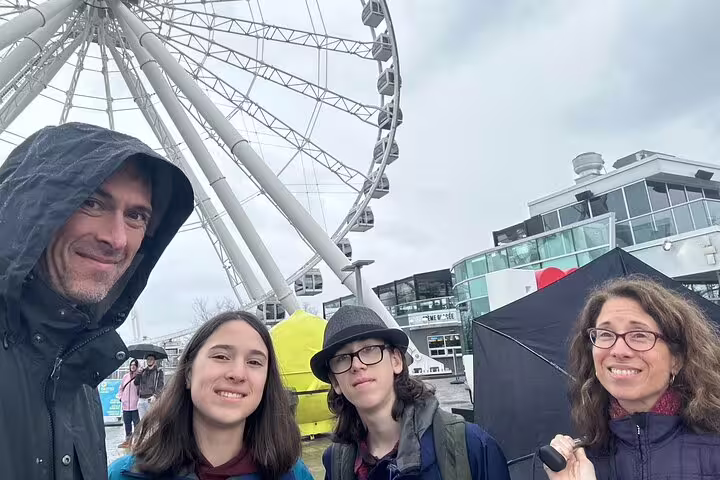 Group selfie at Montréal Old Port by La Grande Roue, highlighting a fun scavenger hunt city walking tour
