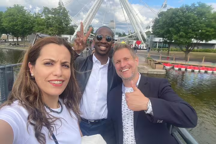 Smiling group by Montréal Old Port waterfront with La Grande Roue, on a city highlights scavenger hunt walk