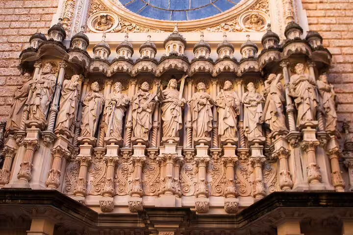 Exquisite statues adorn Montserrat's basilica facade, showcasing intricate artistry on a full-day tour with winery experience.