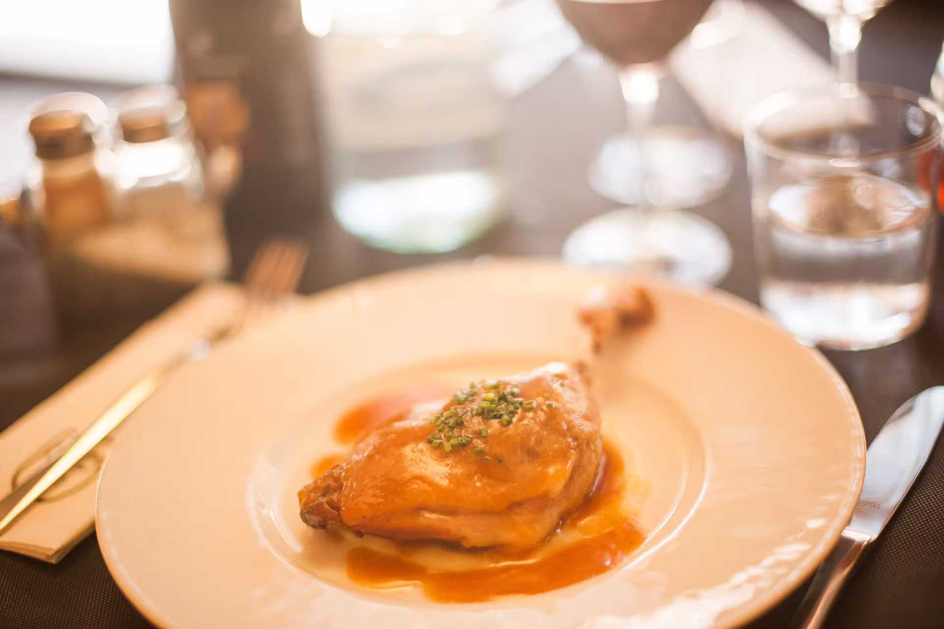 Gourmet duck leg dish served with sauce as part of the Montserrat food and wine tour dining experience.