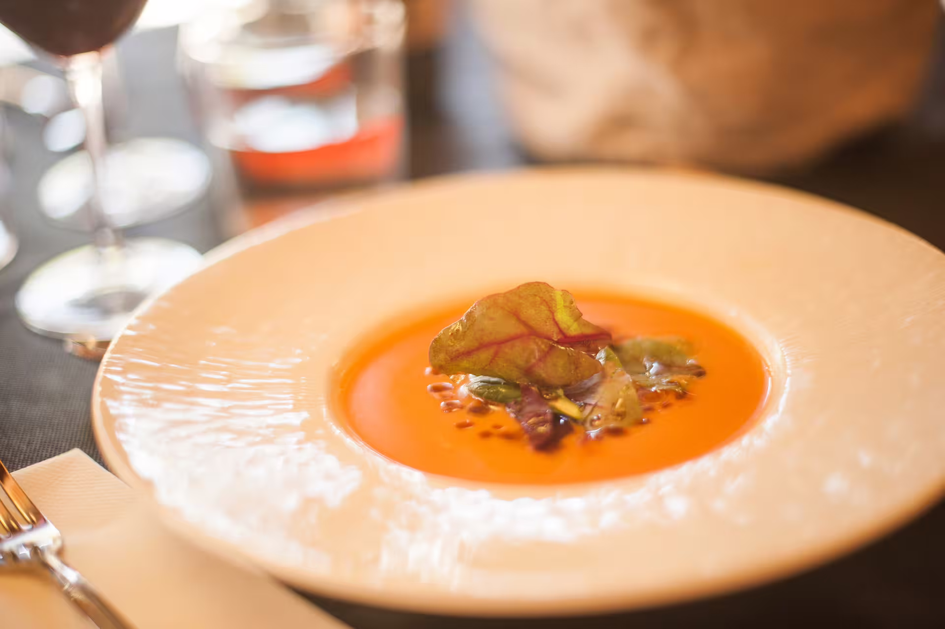 Gourmet pumpkin soup garnished with fresh herbs, perfect for Montserrat food and wine tours.