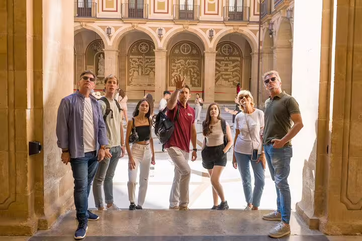 Tourists explore Montserrat's historic courtyard on a guided full-day tour with farmhouse lunch and winery experience.