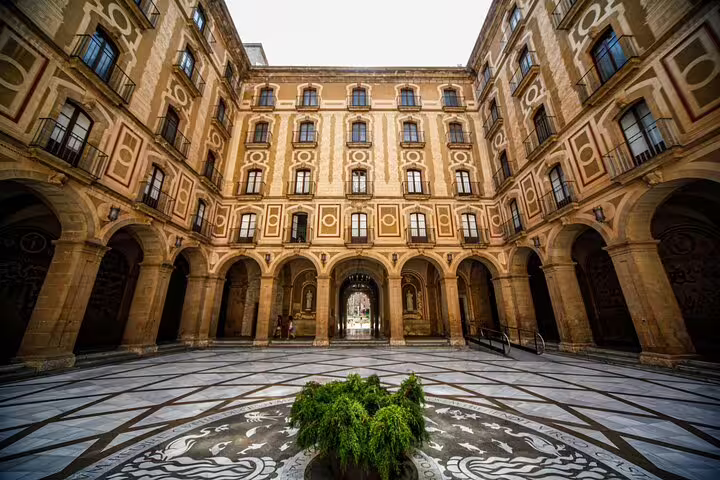 Explore Montserrat's historic courtyard with intricate architecture on a private half-day tour with hotel pick-up.