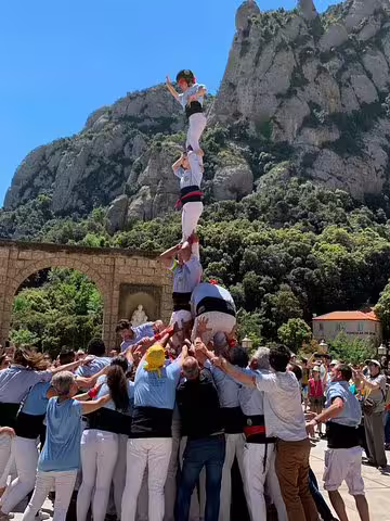 A human tower formation against Montserrat's scenic backdrop, showcasing local culture during a private tour with lunch and Penedes winery visit.