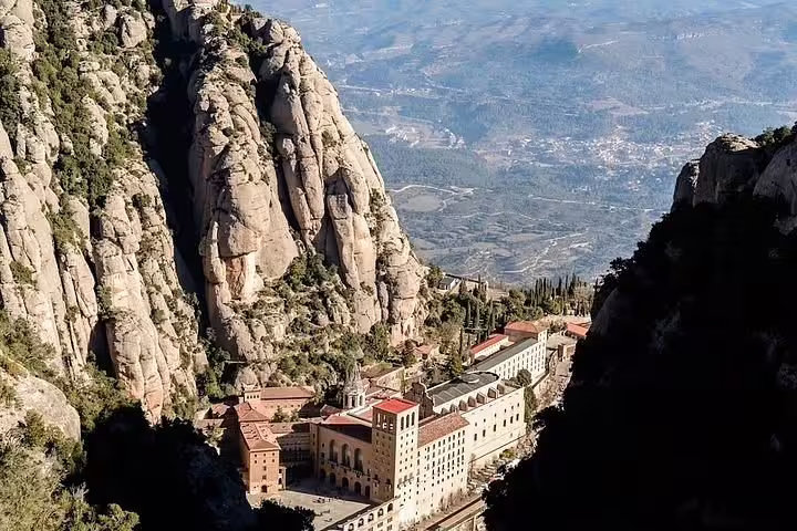Aerial view of Montserrat Monastery nestled in the majestic mountains, a highlight of the Montserrat + Penedés Wine Tour.