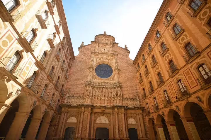 Stunning view of Montserrat's historic monastery facade, a key highlight of the Barcelona tour with convenient hotel pick-up.