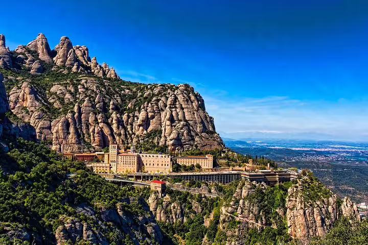 Scenic view of Montserrat Monastery nestled in rugged mountains, ideal for Barcelona highlights tour with hotel or port pickup.