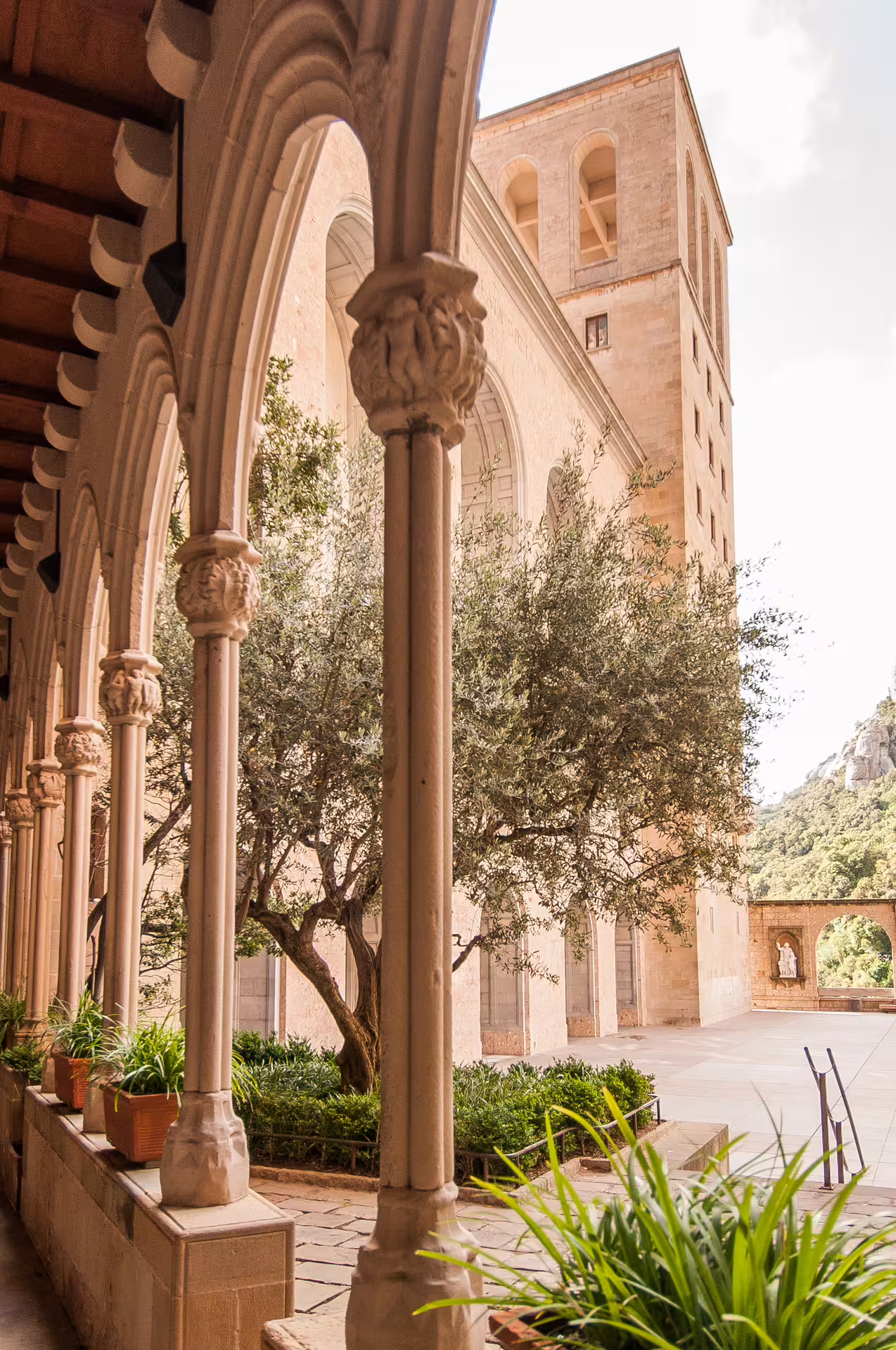 Enchanting view of Montserrat Monastery's historic courtyard arches, perfect for a serene food and wine tour.
