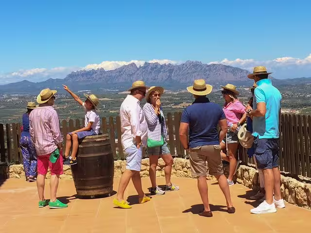 Tourists enjoy panoramic views of Montserrat and Penedes vineyards during a private tour with lunch and wine tasting experience.